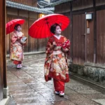 Two maiko geisha walking in a street in Kyoto