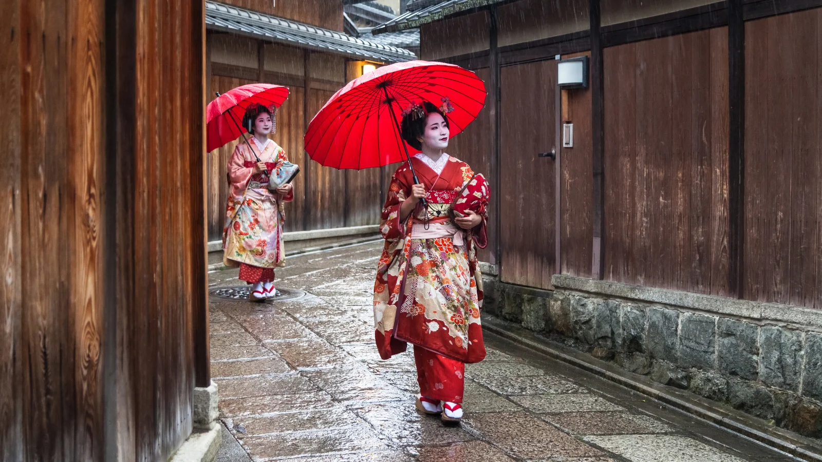 Two maiko geisha walking in a street in Kyoto