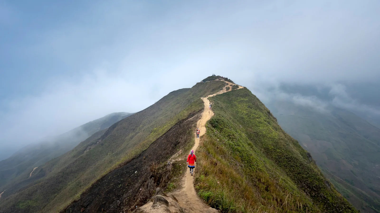 traveler walking along mountain ridge path during slow travel journey