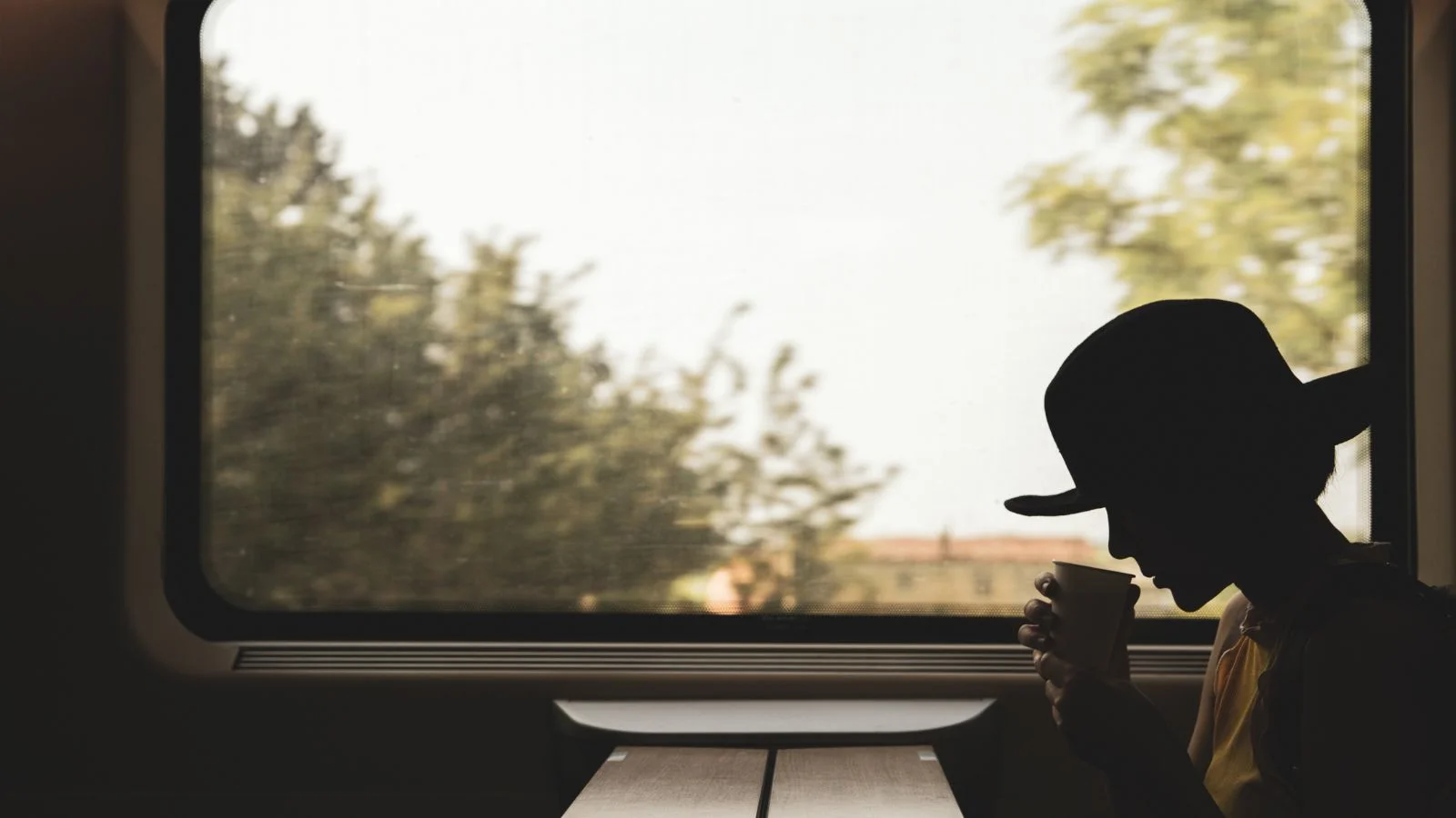 A woman drinking coffee in a train cabin